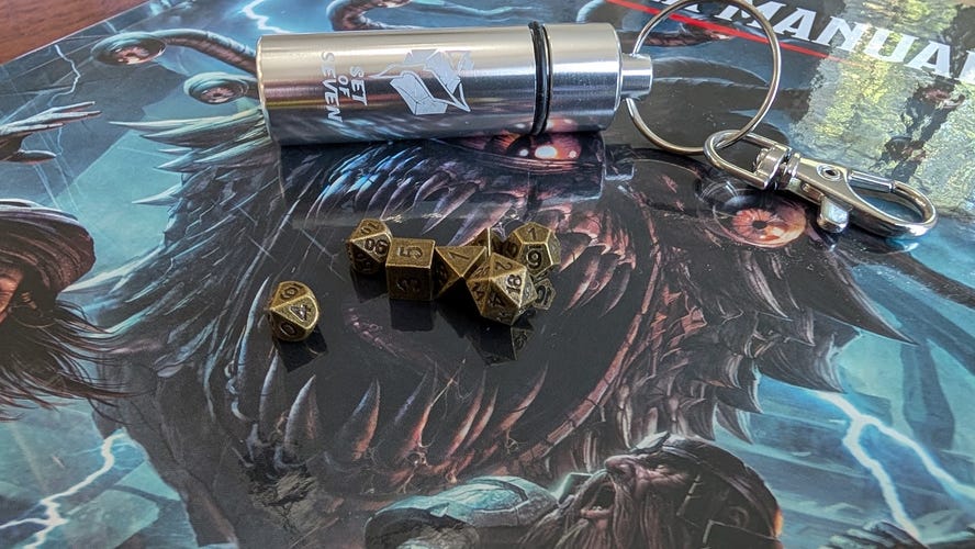 Small metal dice with a capsule to hold them. 