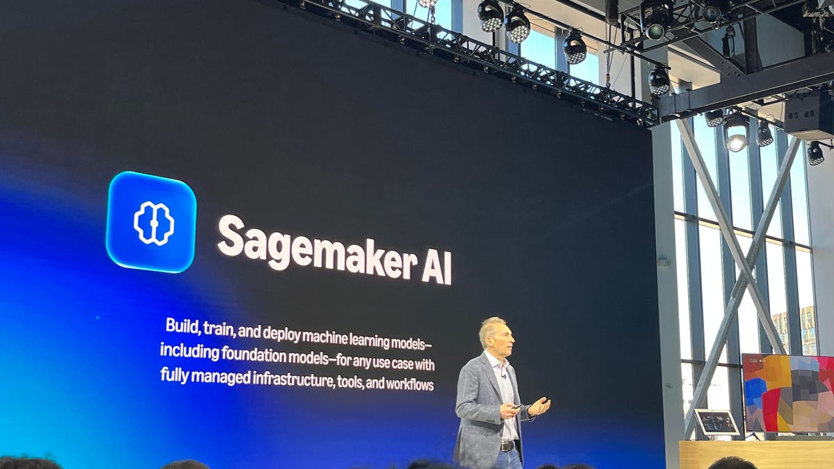 Amazon CEO Andy Jassy on stage in front of a sign with the words Sagemaker AI