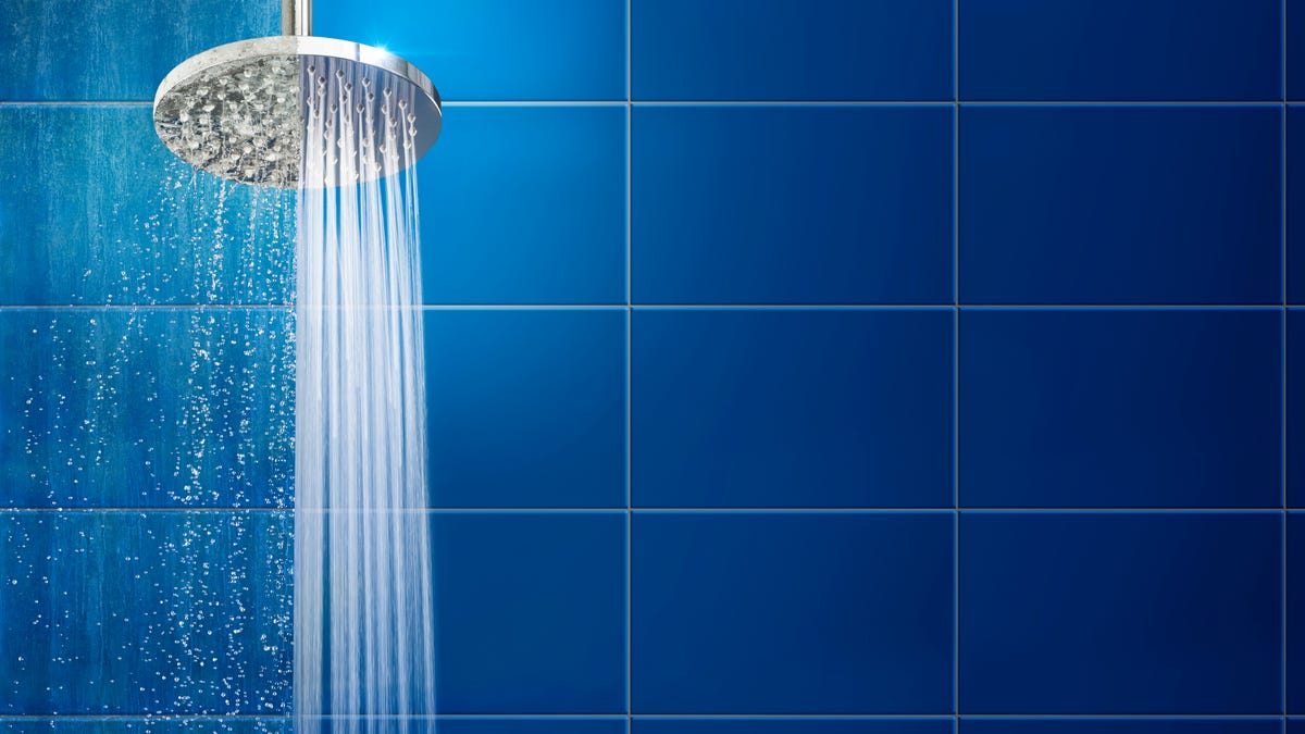A shower head spraying water gently on one side, fiercely on the other