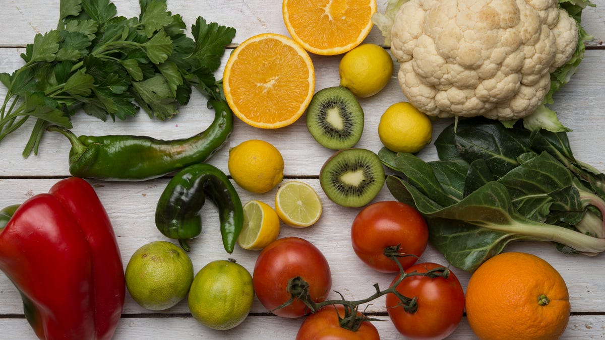 Various fruits and vegetables, including oranges, peppers, tomatoes and herbs.