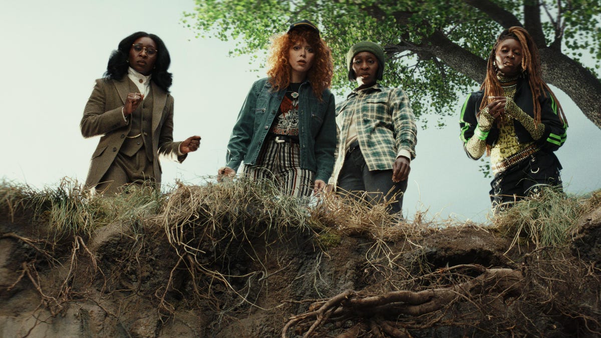 four women stare down toward a ditch