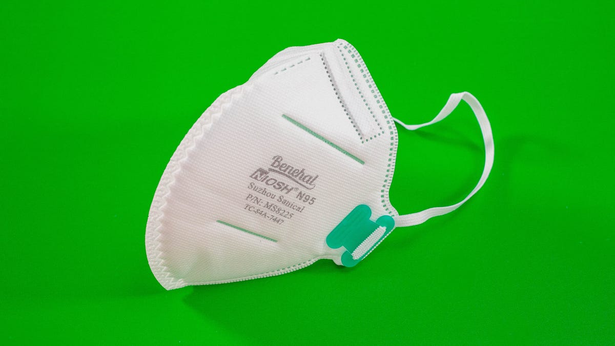 a white N95 mask on a green background