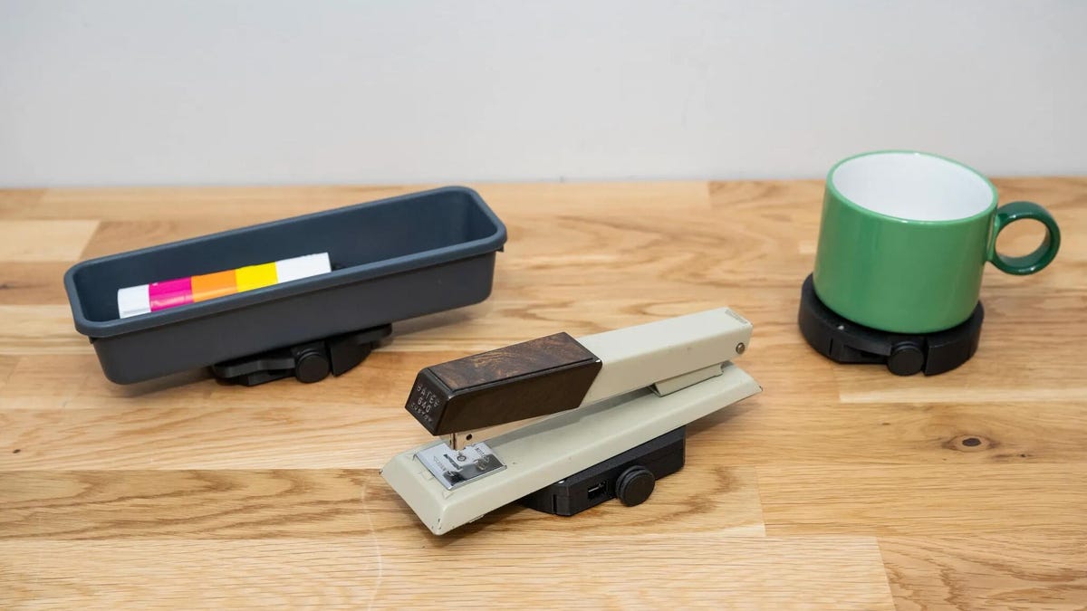 A pencil tray, stapler and coffee mug mounted on wheeled platforms.