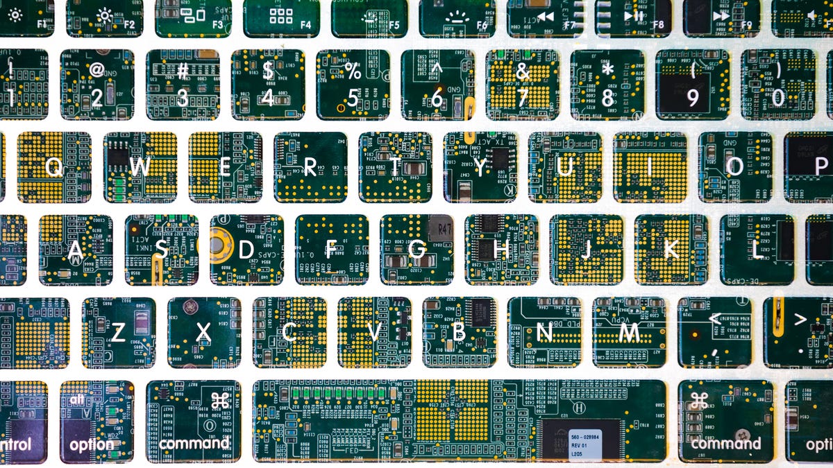 The outline of a computer keyboard superimposed over a purple and green circuit board.