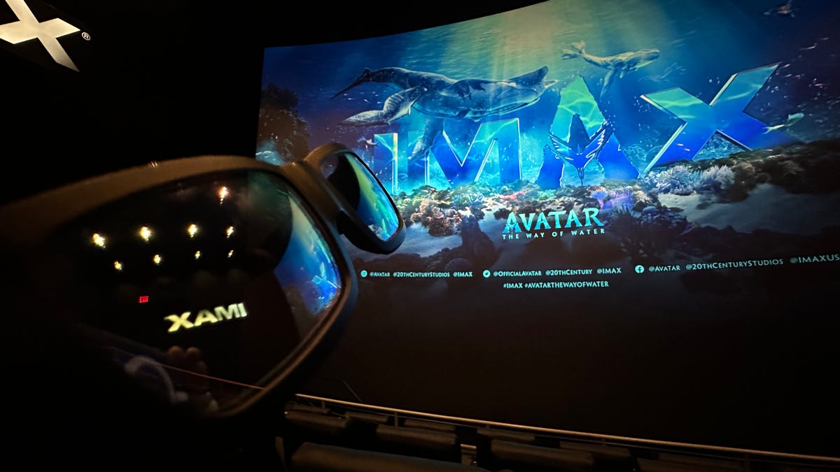 3D glasses held next to a movie screen showing Avatar