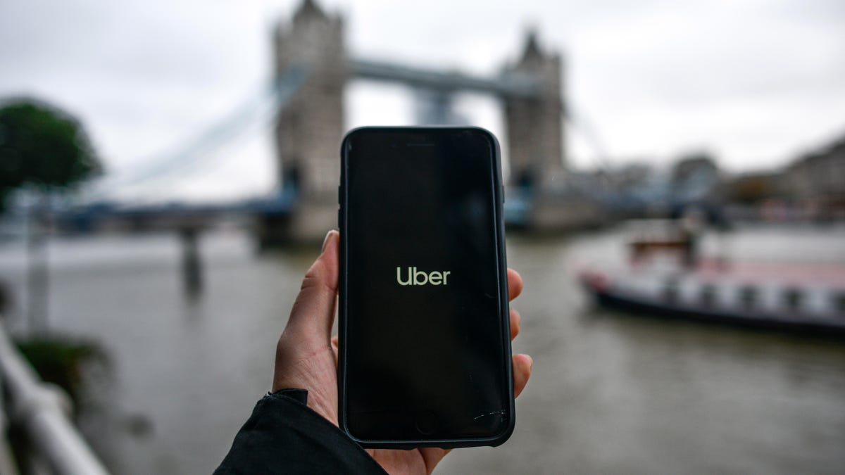 Uber logo on a smartphone screen in front of London's Tower Bridge