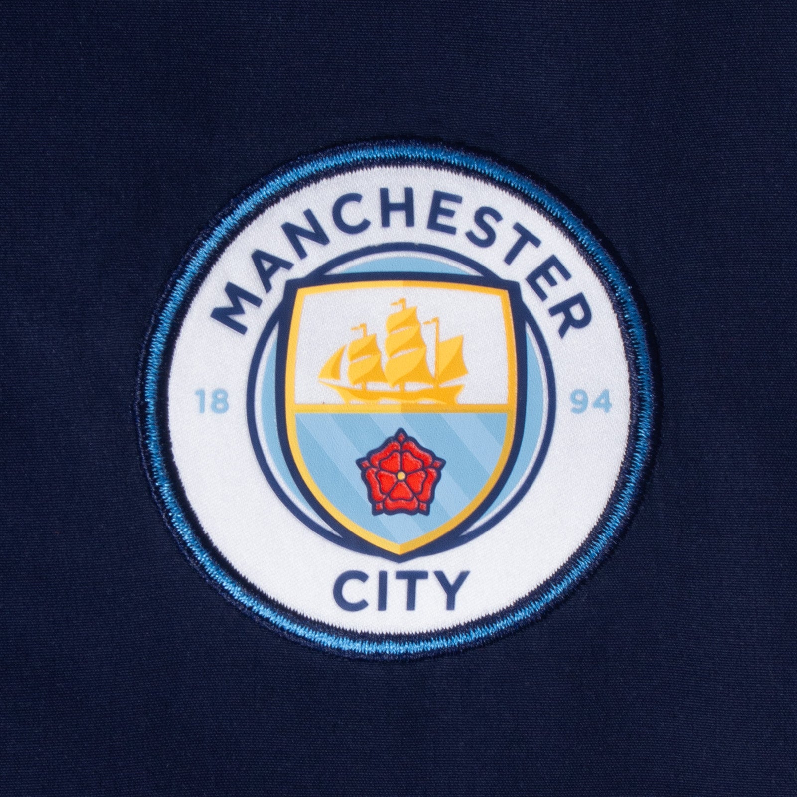 Man City kids tracksuit in navy blue with club crest to chest and left thigh