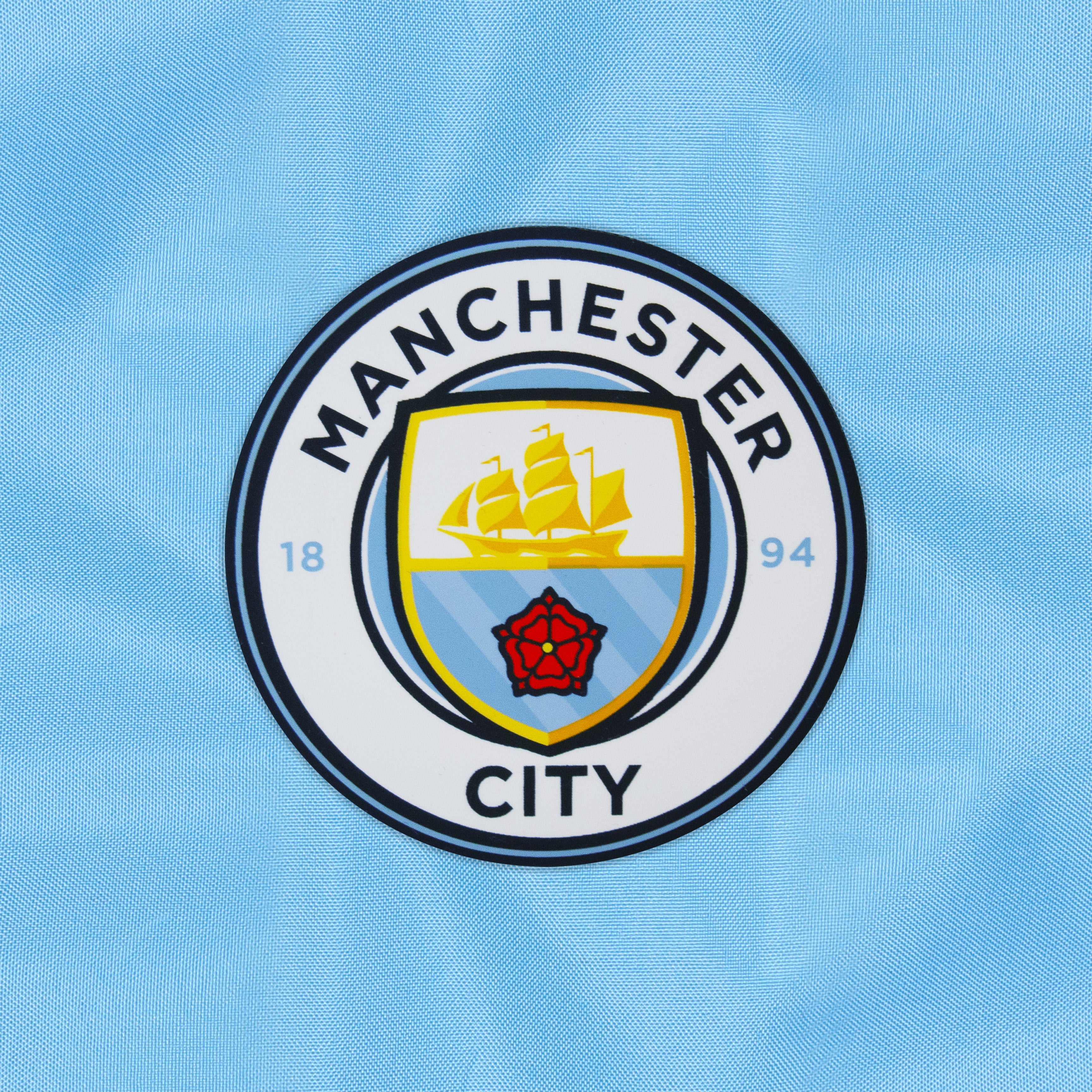 Man City kids shower jacket in blue with club crest to chest.
