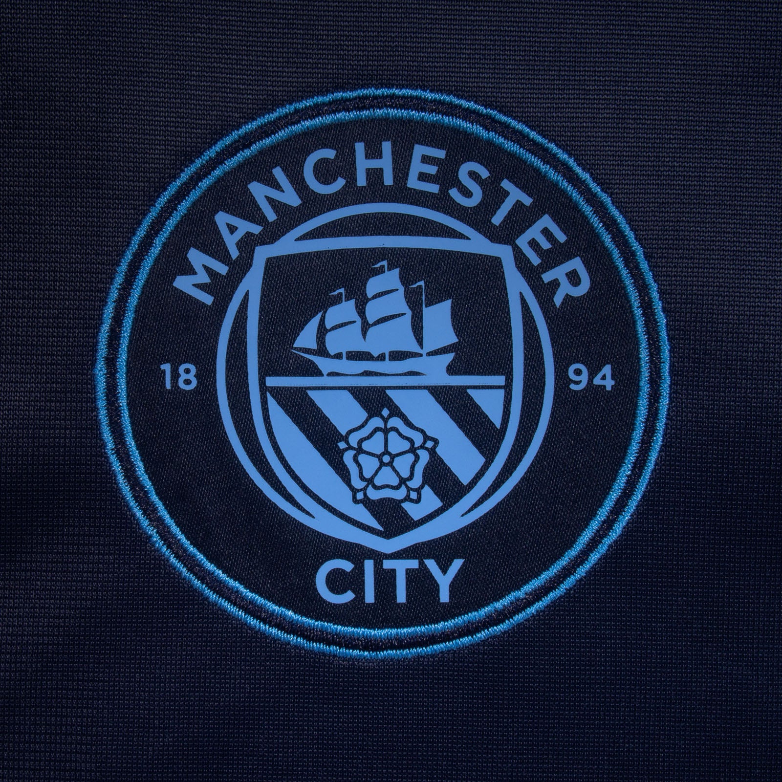 Manchester City adults taped tracksuit in navy blue with club crest and text to both top & pants
